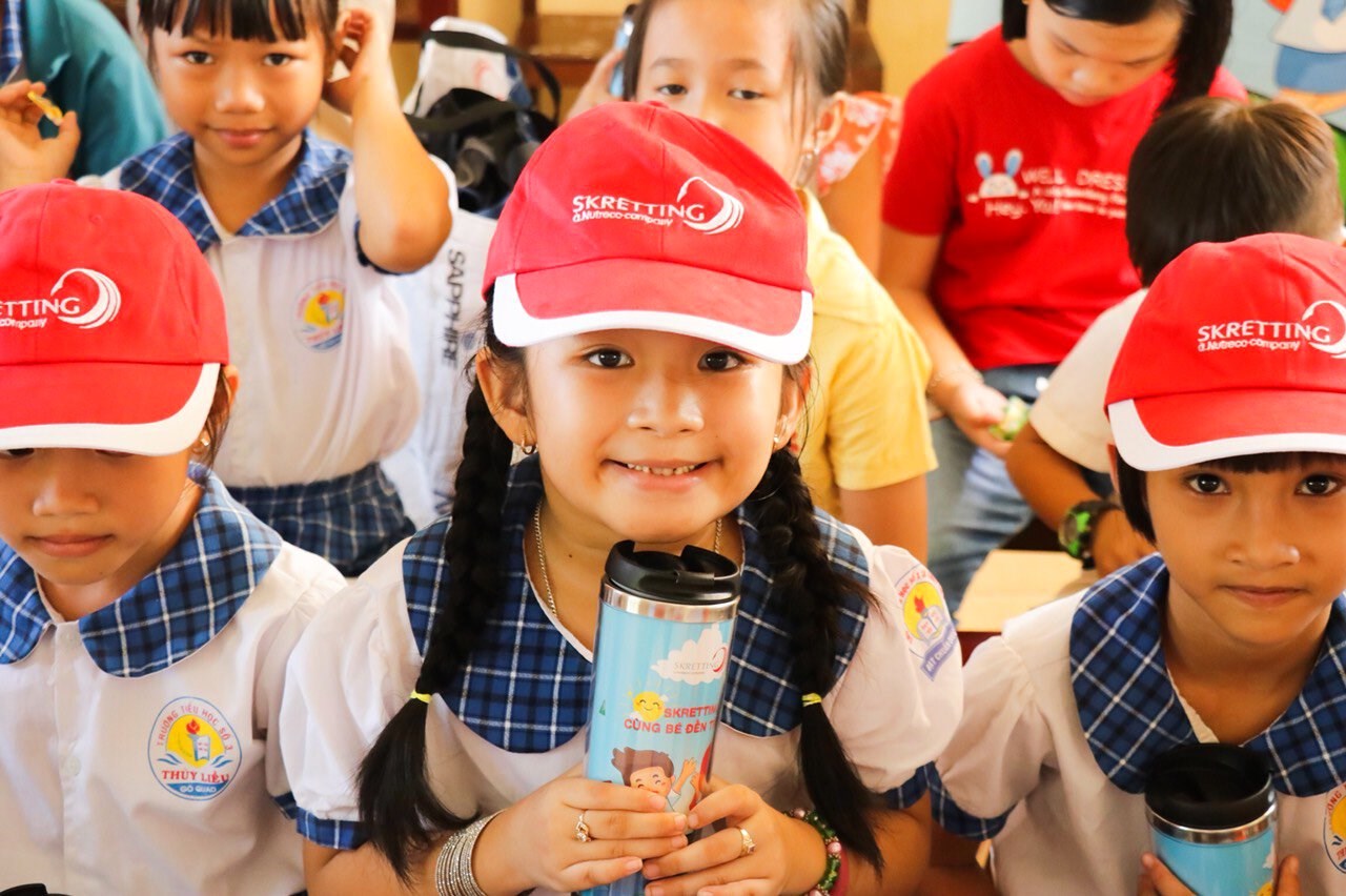 Vietnamese children wearing Skretting caps