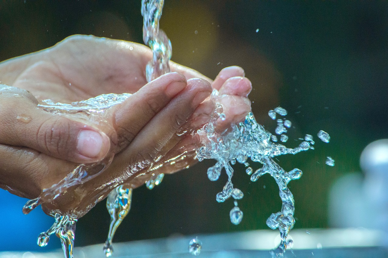 Hands being washed with soap under tap