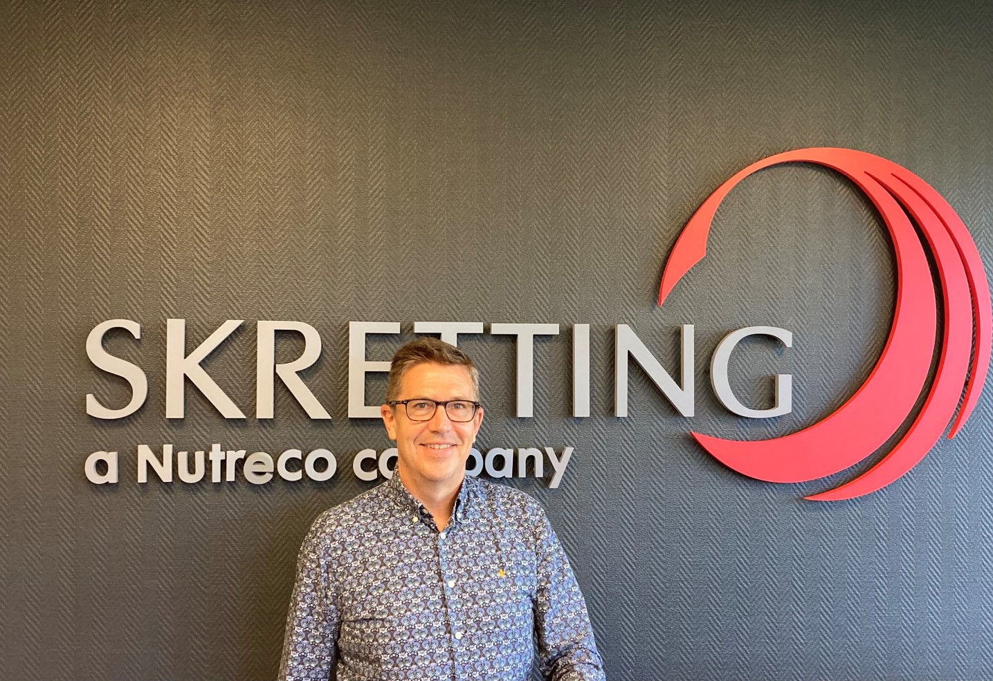 Charlie Granfelt in front of Skretting logo