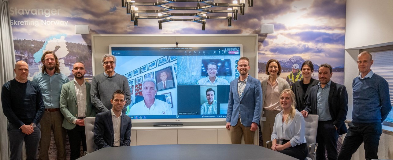 People standing in meeting room and on screen in the background, from the Nutreco Klaas Puul meeting