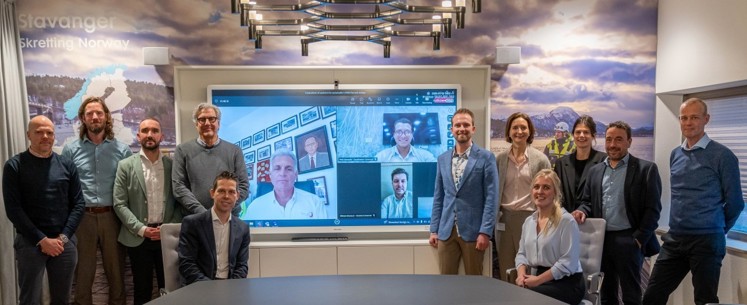 People standing in meeting room and on screen in the background, from the Nutreco Klaas Puul meeting