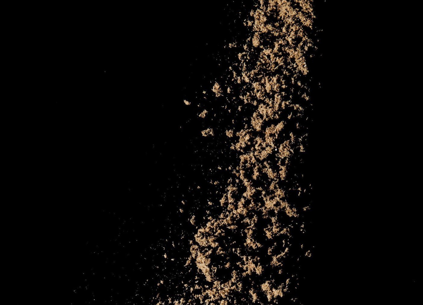 Fish meal dropping from above with a black background