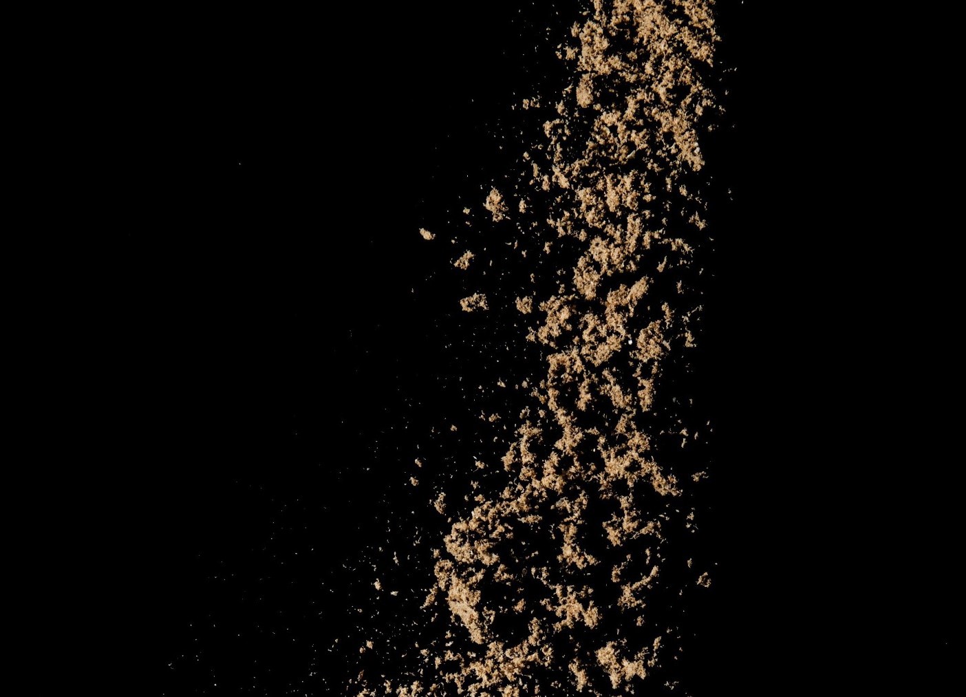 Fish meal dropping from above with a black background